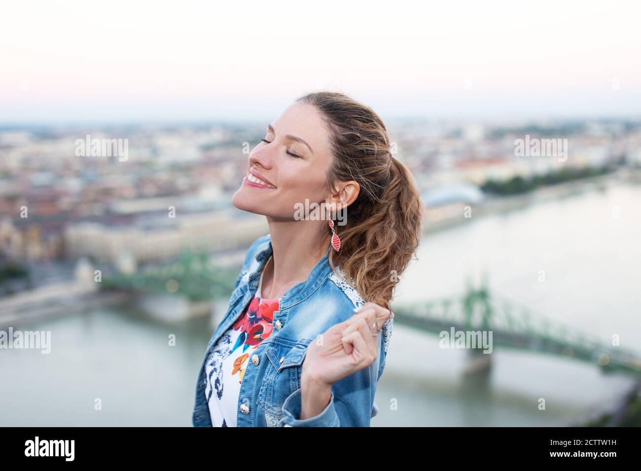 Jeune femme joyeuse se détendant au-dessus de la ville de Budapest, Hongrie Banque D'Images