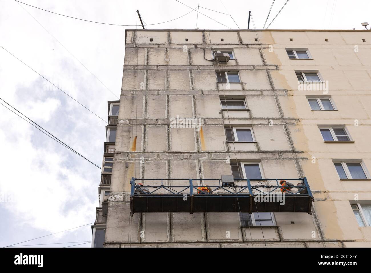 Rénovation de la façade d'un ancien bâtiment. Travailleurs dans un berceau suspendu Banque D'Images