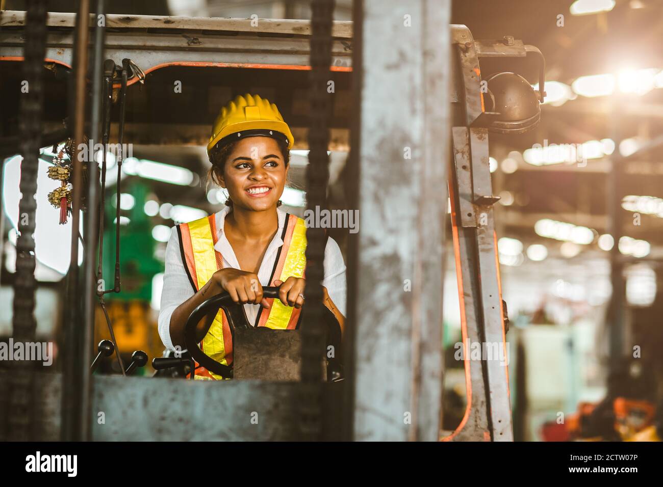 Les femmes noires américaines travaillent au conducteur de chariot élévateur heureux de travailler dans l'entrepôt logistique de l'usine industrielle d'expédition. Banque D'Images