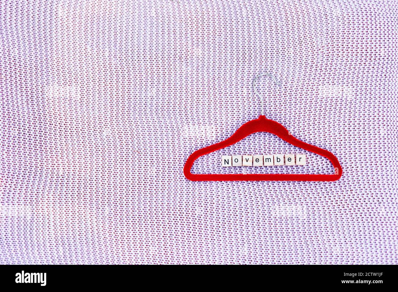 Porte-vêtements sur fond tricoté avec un mot composé à partir des lettres Banque D'Images