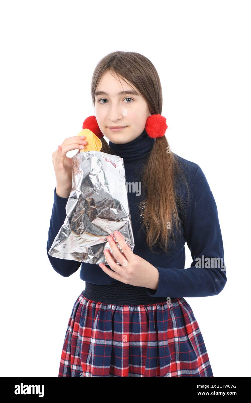 Portrait d'une jeune fille préadolescente tenant des chips de pomme de terre. Isolé sur fond blanc. Photo haute résolution. Profondeur de champ complète. Banque D'Images