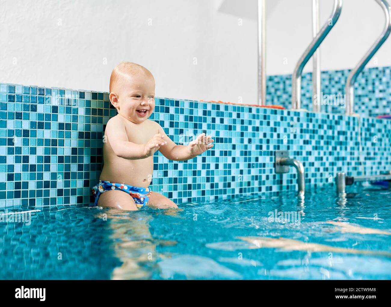 Un Adorable Bebe Joueur Est Assis Sur Un Tube D Argent Dans La Piscine Pour Se Preparer A Sauter Dans L Eau Jusqu Aux Mains De Sa Mere Concept De Chindhood Sain Photo Stock Un Adorable Bebe Joueur Est Assis Sur Un Tube D Argent Dans La Piscine Pour Se Preparer A Sauter Dans L Eau Jusqu Aux Mains De Sa Mere Concept De Chindhood Sain Photo Stock