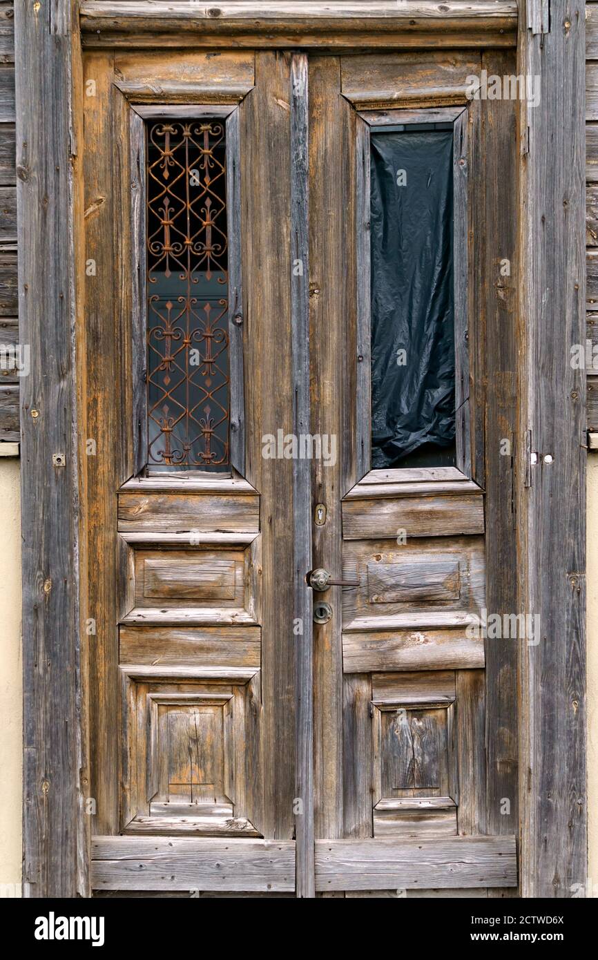 Une ancienne porte en bois cassée dans une maison avec des inserts magnifiquement conservés. Banque D'Images