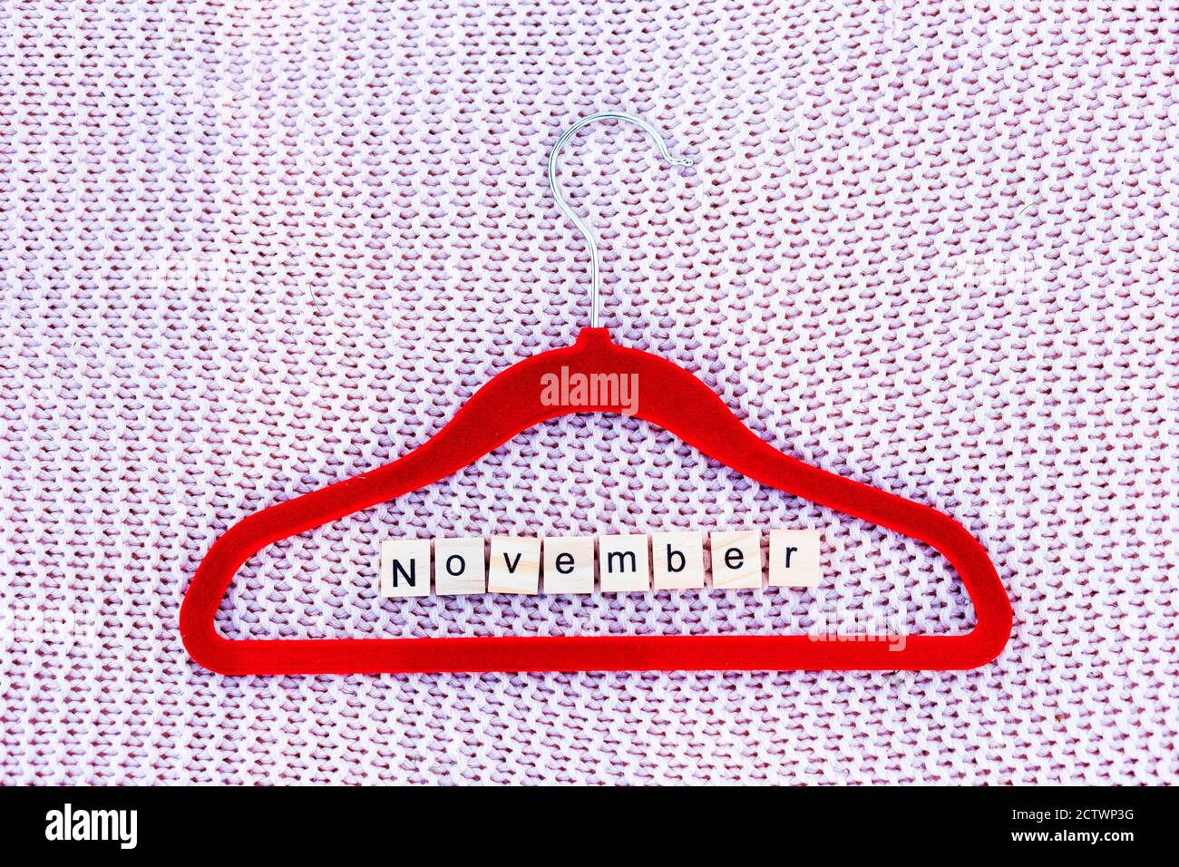 Porte-vêtements sur fond tricoté avec un mot composé à partir des lettres Banque D'Images
