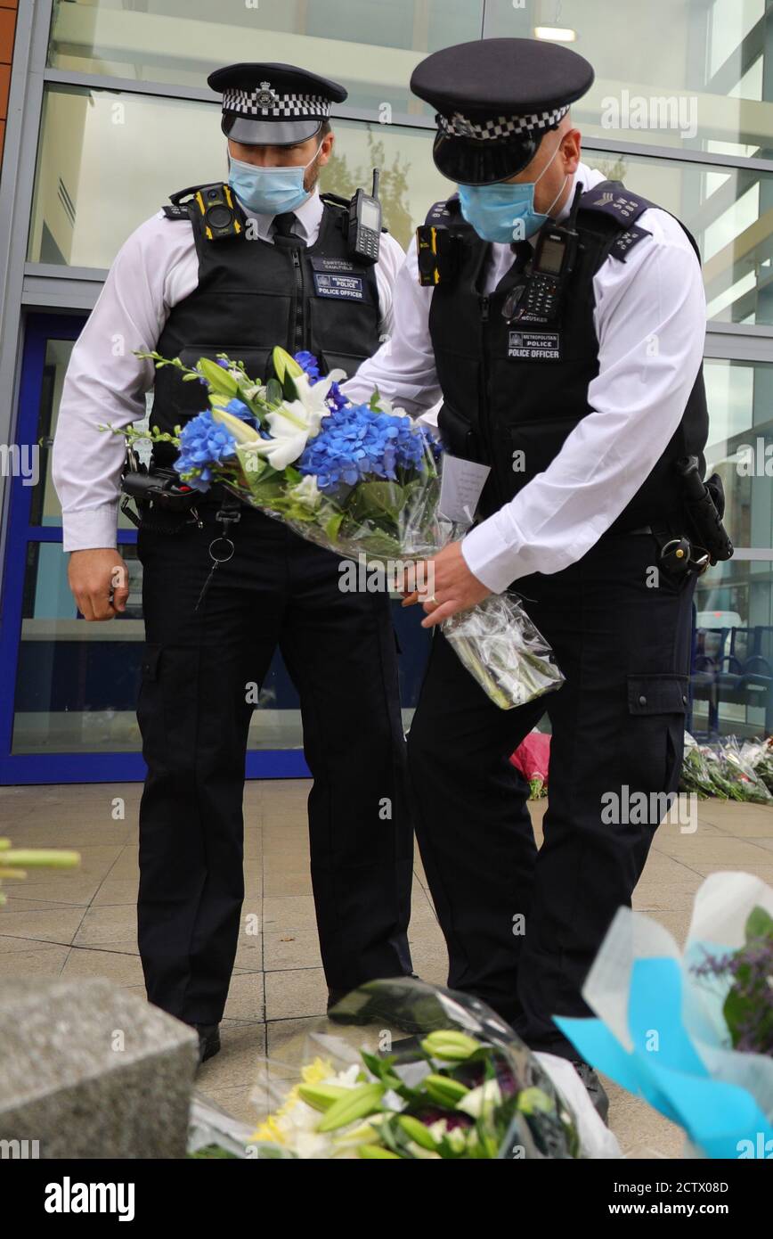 Des policiers latent des fleurs devant le centre de détention de Croydon, dans le sud de Londres, où un autre policier a été abattu par un homme qui était détenu dans les premières heures de vendredi matin. L'officier a été soigné sur les lieux avant d'être transporté à l'hôpital où il est décédé par la suite. Banque D'Images