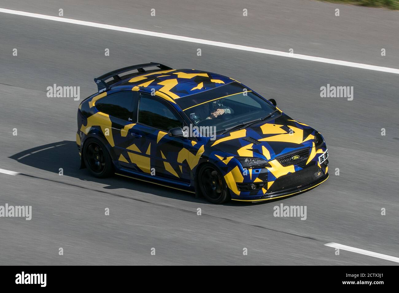 2006 jaune noir personnalisé Ford Focus St-2 en voiture sur l'autoroute M6 près de Preston à Lancashire, Royaume-Uni. Banque D'Images