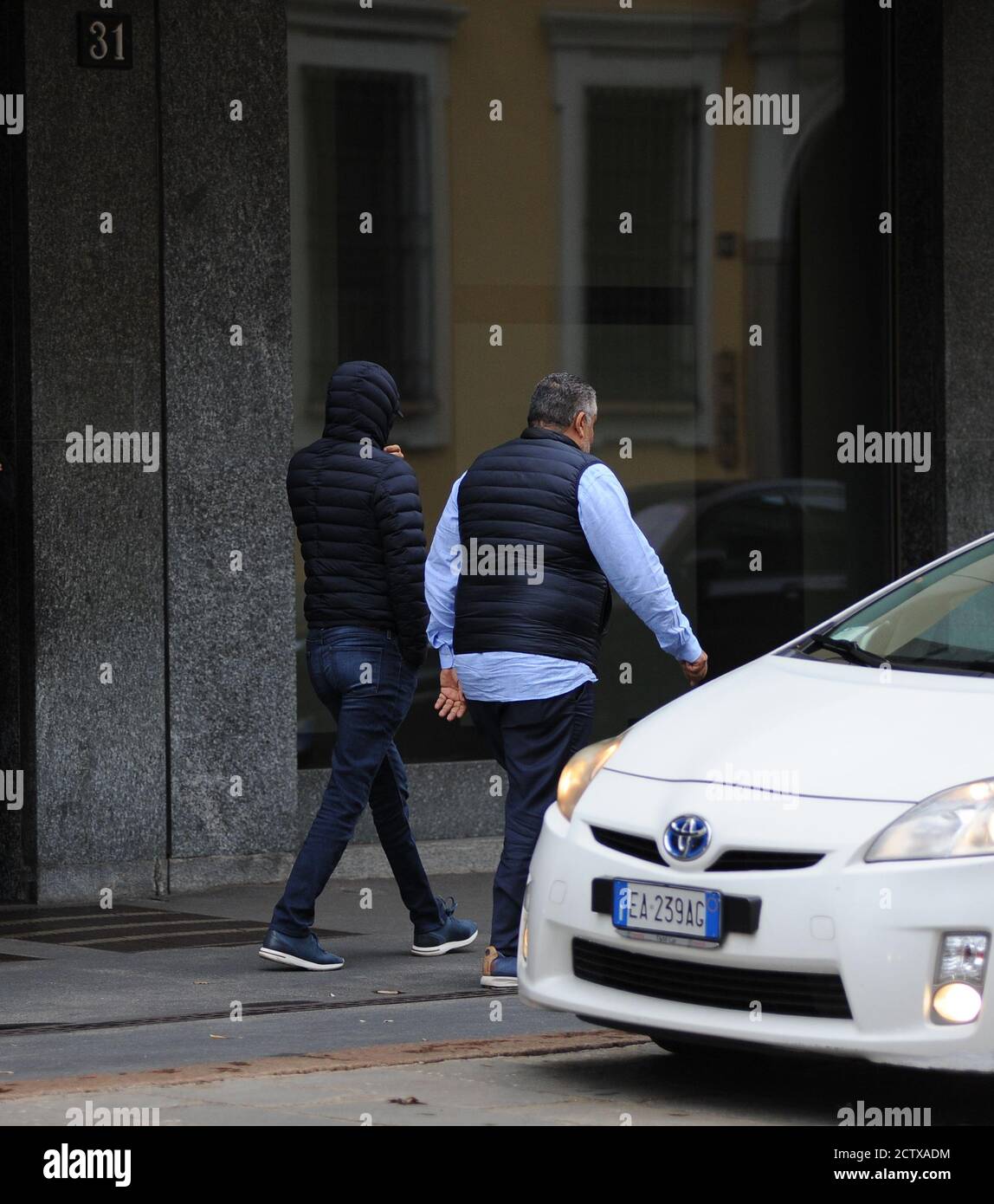 Milan, Nasser Al Khelaifi au centre dans le déguisement le Président de Paris Saint Germain, vainqueur du championnat français, NASSER AL KHELAIFI sous enquête pour la cession des droits TV de la coupe du monde des Confédérations par la FIFA à ses sports belN, La propriété de son réseau mondial pour cela la Cour pénale fédérale de Bellinzona en Suisse a demandé une peine de 28 mois de prison. Dans les photos NASSER AU KHELAIFI après avoir déjeuné dans un restaurant du centre de Milan, il marche vers son hôtel, cachant son visage avec un masque, des lunettes, une cagoule de veste, escorté par un homme qui Banque D'Images