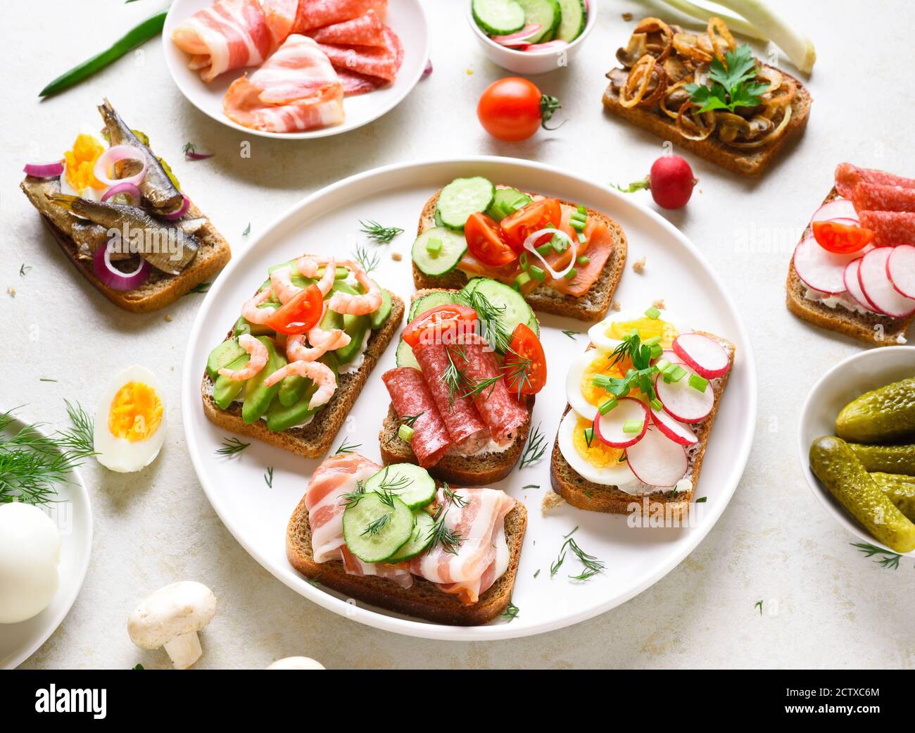 Sandwichs ouverts à base de viande, de légumes et de fruits de mer sur fond de pierre légère. En-cas savoureux et sains. Banque D'Images