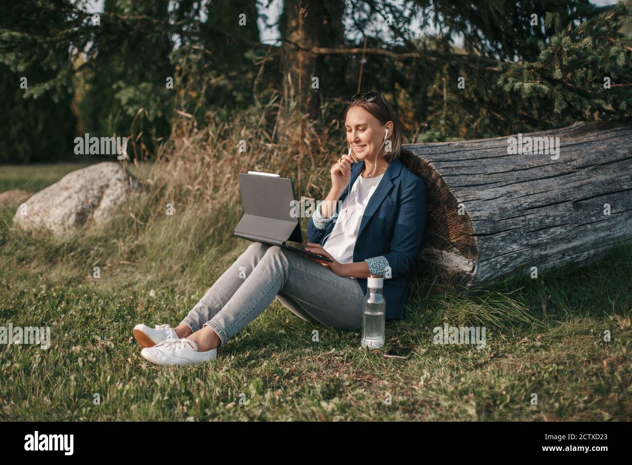 Espace de travail extérieur. Femme travaillant sur un ordinateur portable dans le parc. Travail à distance au cours de la quarantaine du coronavirus covid-19. Étudiant étudiant étudiant en ligne. Banque D'Images