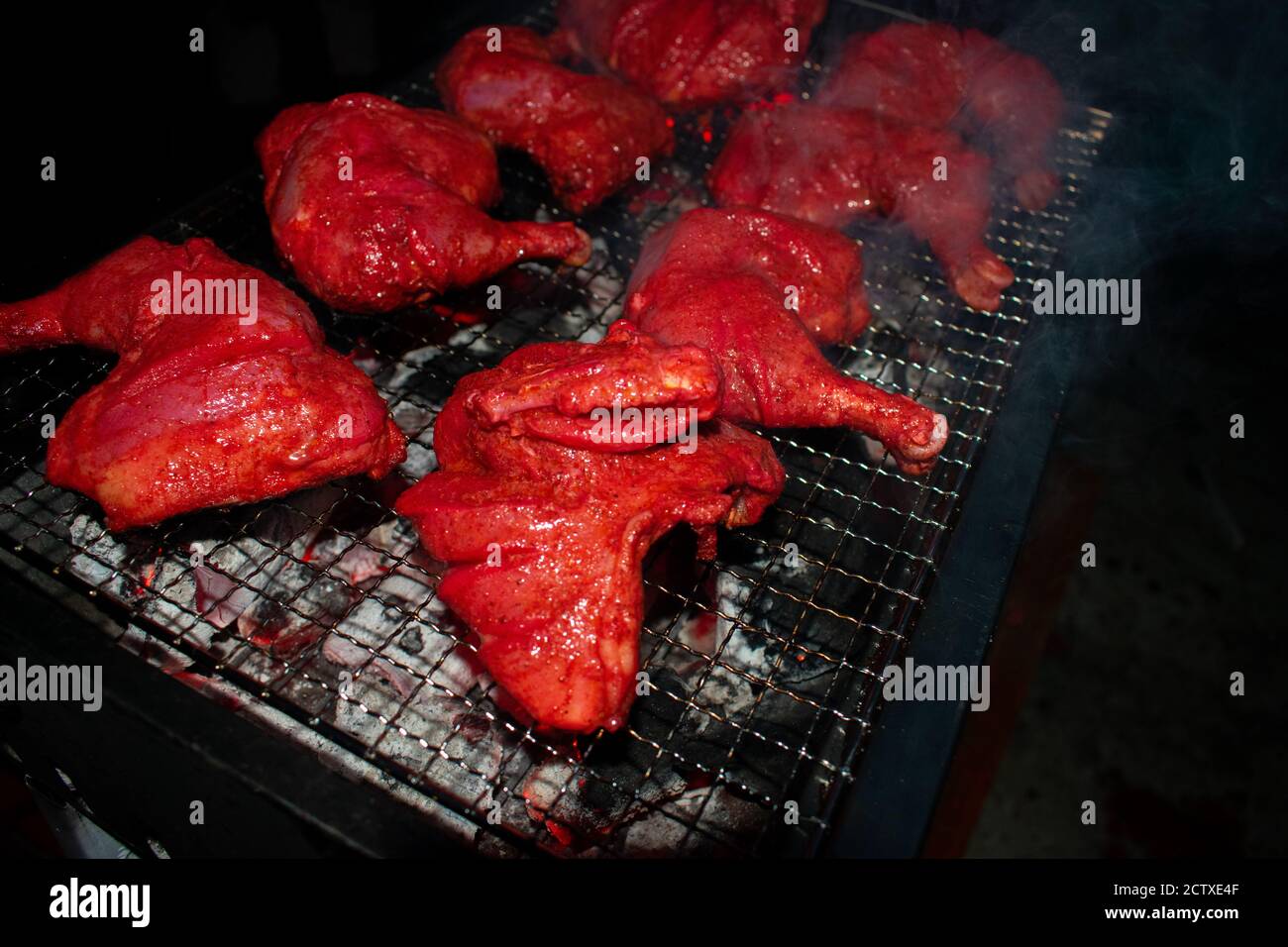 Cuisson au poulet grillé pour les dîners : cuisson au barbecue fumé pour la fête dans la nuit d'hiver. Banque D'Images