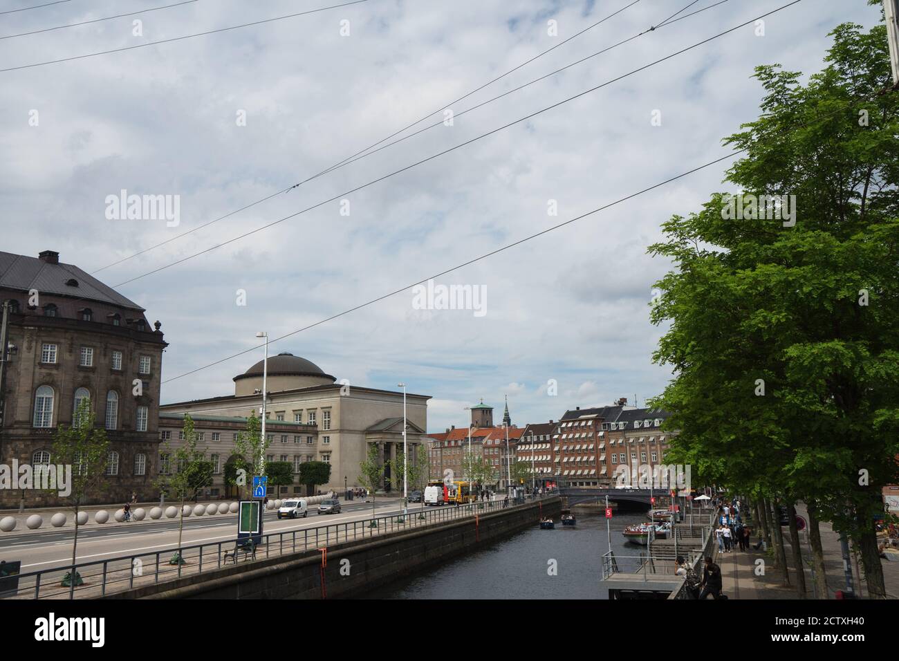 Front de mer, canal et rue à Copenhague, Danemark. Anciennes façades de maisons et de navires le long du canal. Bateaux de tourisme amarrés dans le canal. Banque D'Images