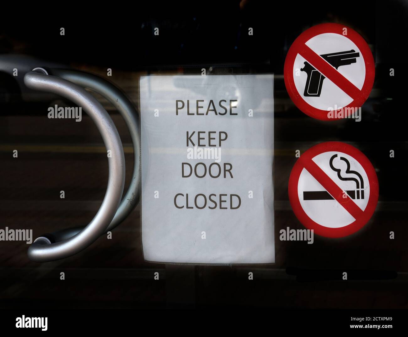 Des panneaux sur la porte d'une banque informent les clients que les armes à feu et le tabagisme ne sont pas autorisés à l'intérieur. Banque D'Images