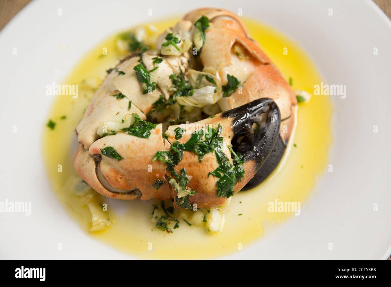 Deux pinces de crabe craqué bouillies provenant d'un crabe brun, cancer pagurus, qui ont été servies avec du beurre d'ail et de persil. Dorset Angleterre GB Banque D'Images