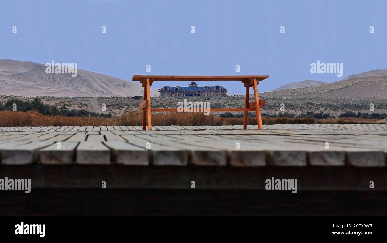 Banc-table jaune-orange sur une promenade en bois qui encadrent le bâtiment de l'hôtel. Lac Badain est-BadainJaran-Chine-1050 Banque D'Images