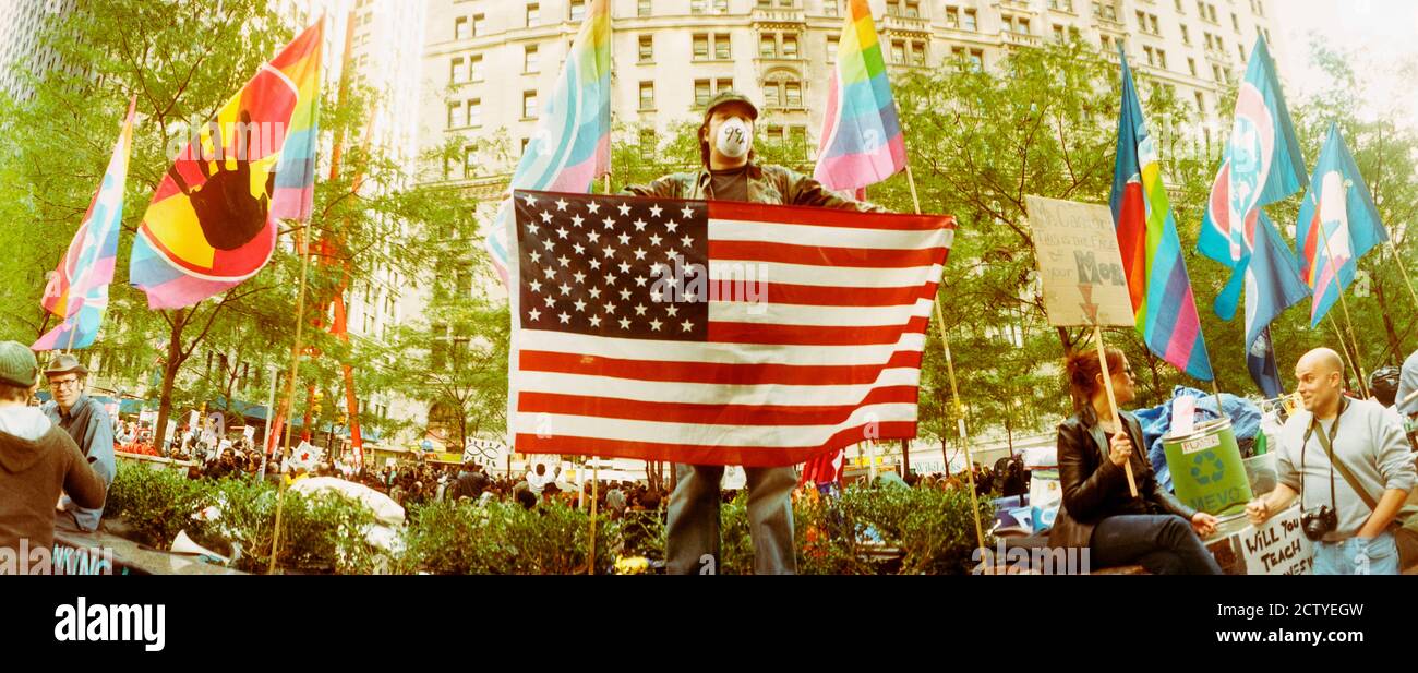 Occupez le manifestant de Wall Street tenant le drapeau américain, Zuccotti Park, Lower Manhattan, Manhattan, New York City, New York State, États-Unis Banque D'Images