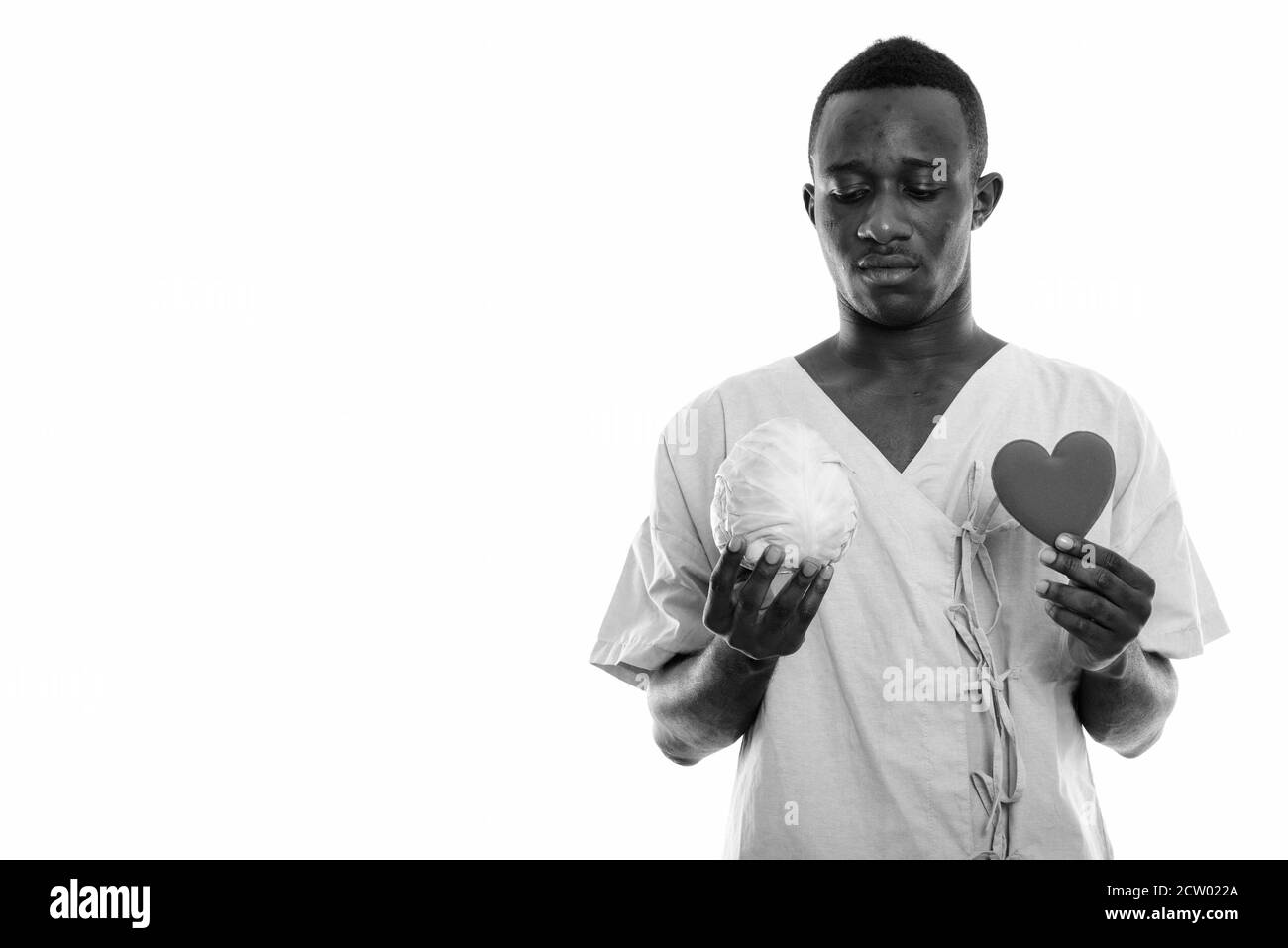 Photo en studio d'un jeune homme africain noir chou et coeur de maintien Banque D'Images