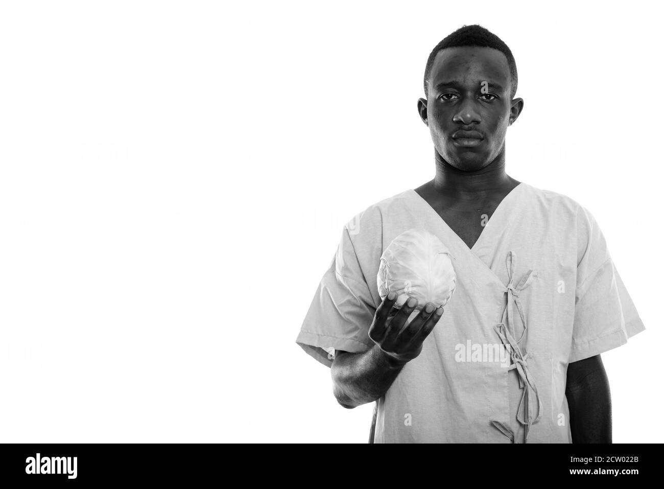 Studio de prise de vue d'un jeune homme africain noir patient tenant le chou Banque D'Images