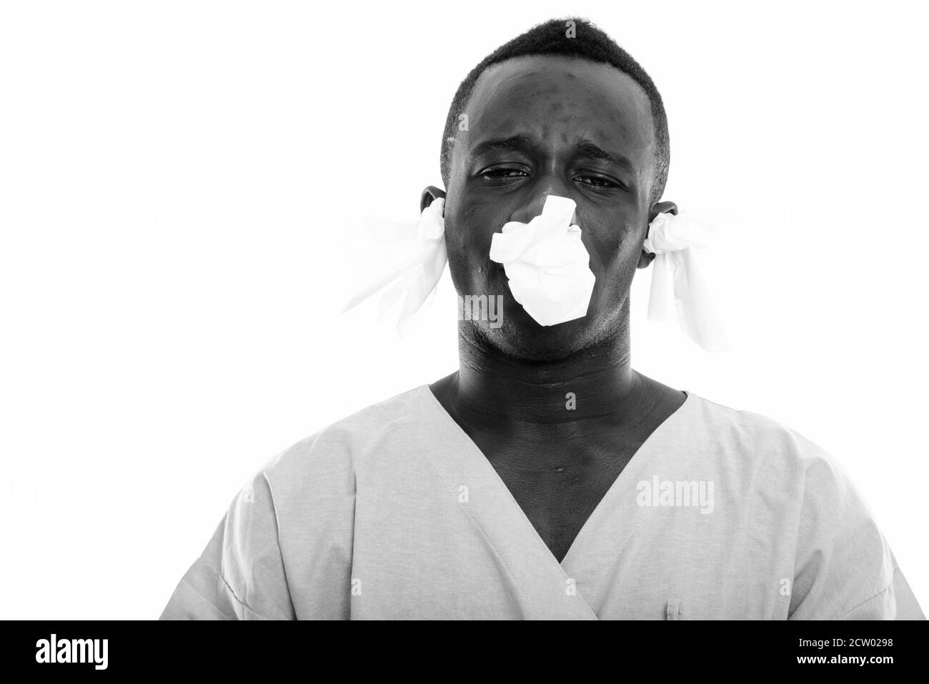 Portrait de jeune homme de l'Afrique noire à la recherche de patients malades avec des tissus dans les oreilles et le nez Banque D'Images