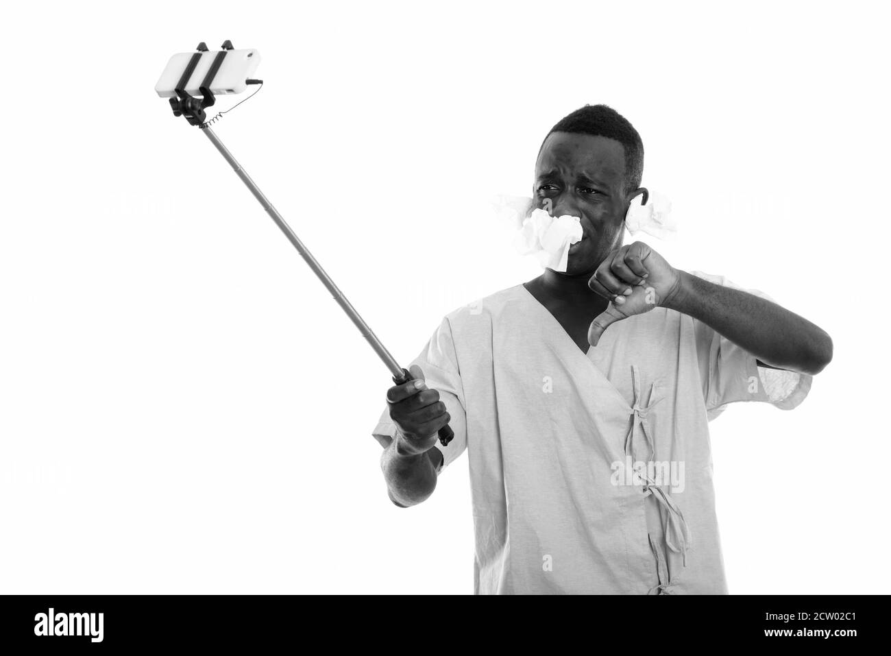 Jeune homme africain malade pendant qu'il prend son selfie téléphone sur bâton pour selfie Banque D'Images