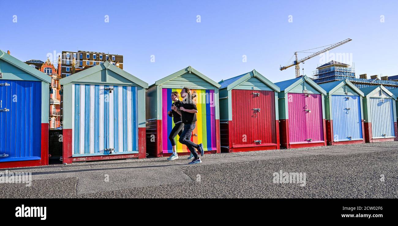 Brighton, Royaume-Uni. 26 septembre 2020. Les coureurs passent par des cabanes de plage colorées le long du front de mer de Hove, le matin d'une matinée lumineuse et ensoleillée mais froide sur la côte sud. : Credit: Simon Dack/Alamy Live News Banque D'Images