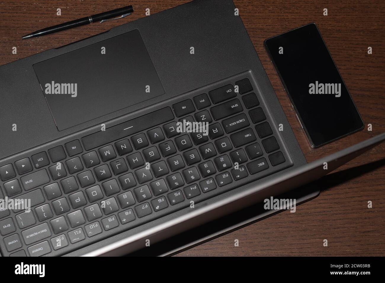 ordinateur portable, téléphone portable et stylo, sur une table en bois Banque D'Images