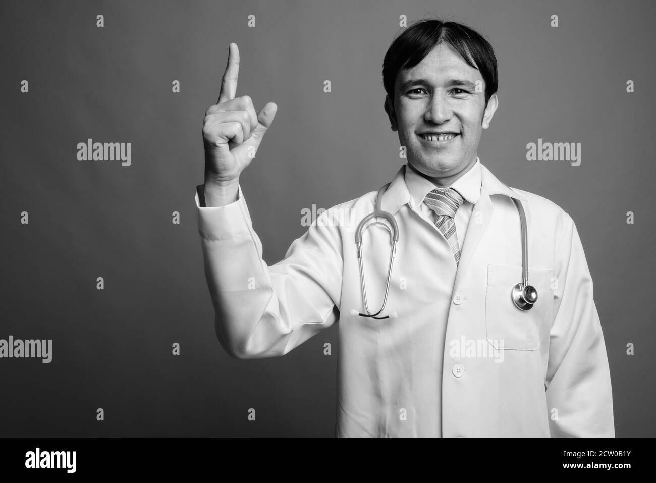 Young Asian man médecin contre l'arrière-plan gris Banque D'Images