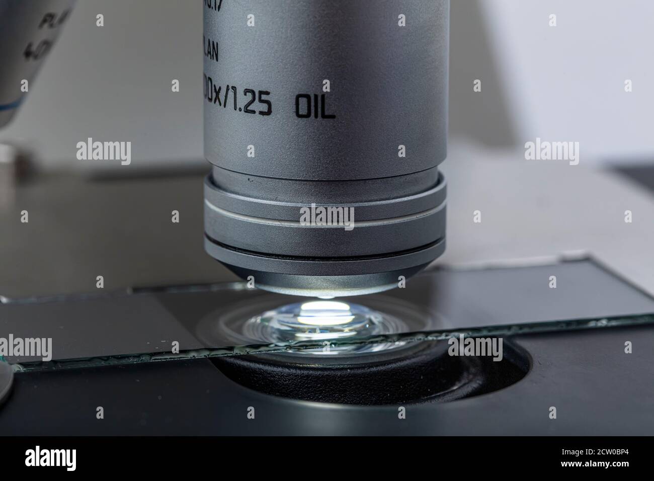 Distribution de l'huile d'immersion sous la lentille de microscope optique.  L'immersion dans l'huile est une technique de microscopie optique haute  résolution Photo Stock - Alamy
