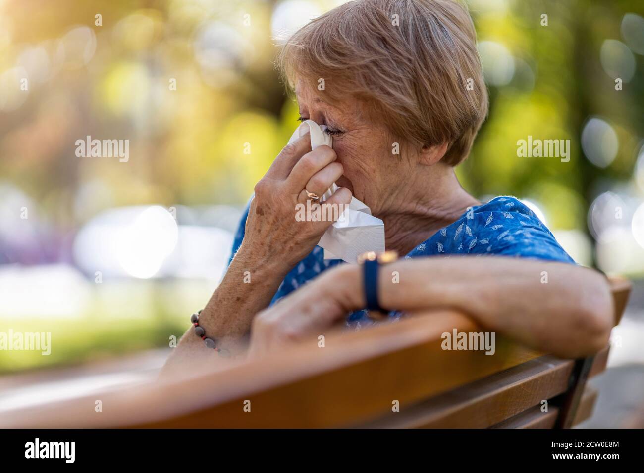 Une femme âgée malheureuse se balade les yeux avec un tissu à l'extérieur Banque D'Images