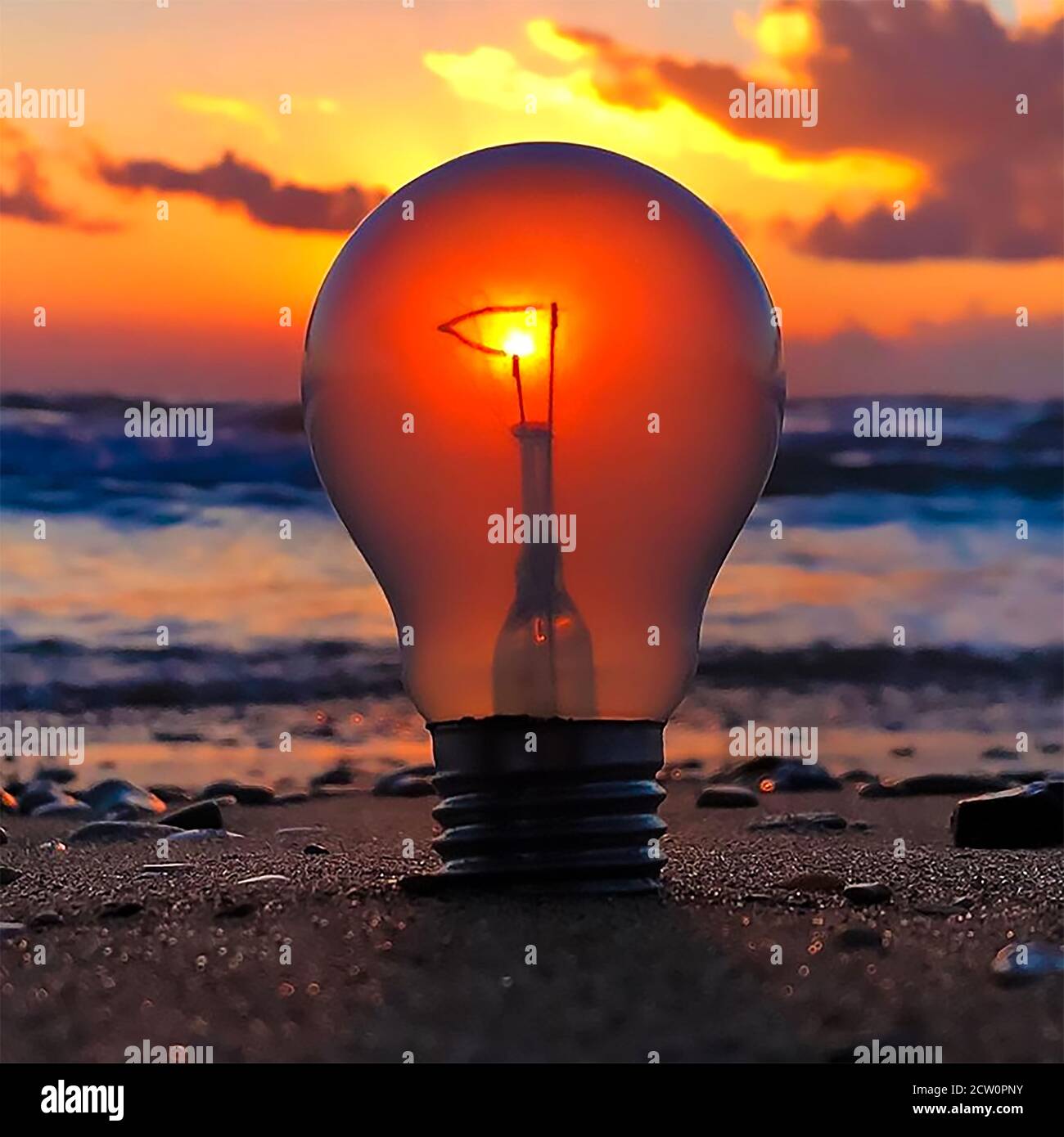 Coucher de soleil avec une ampoule lumineuse dans le sable avec le rayons du soleil qui réfléchit et réfractent la lumière Banque D'Images