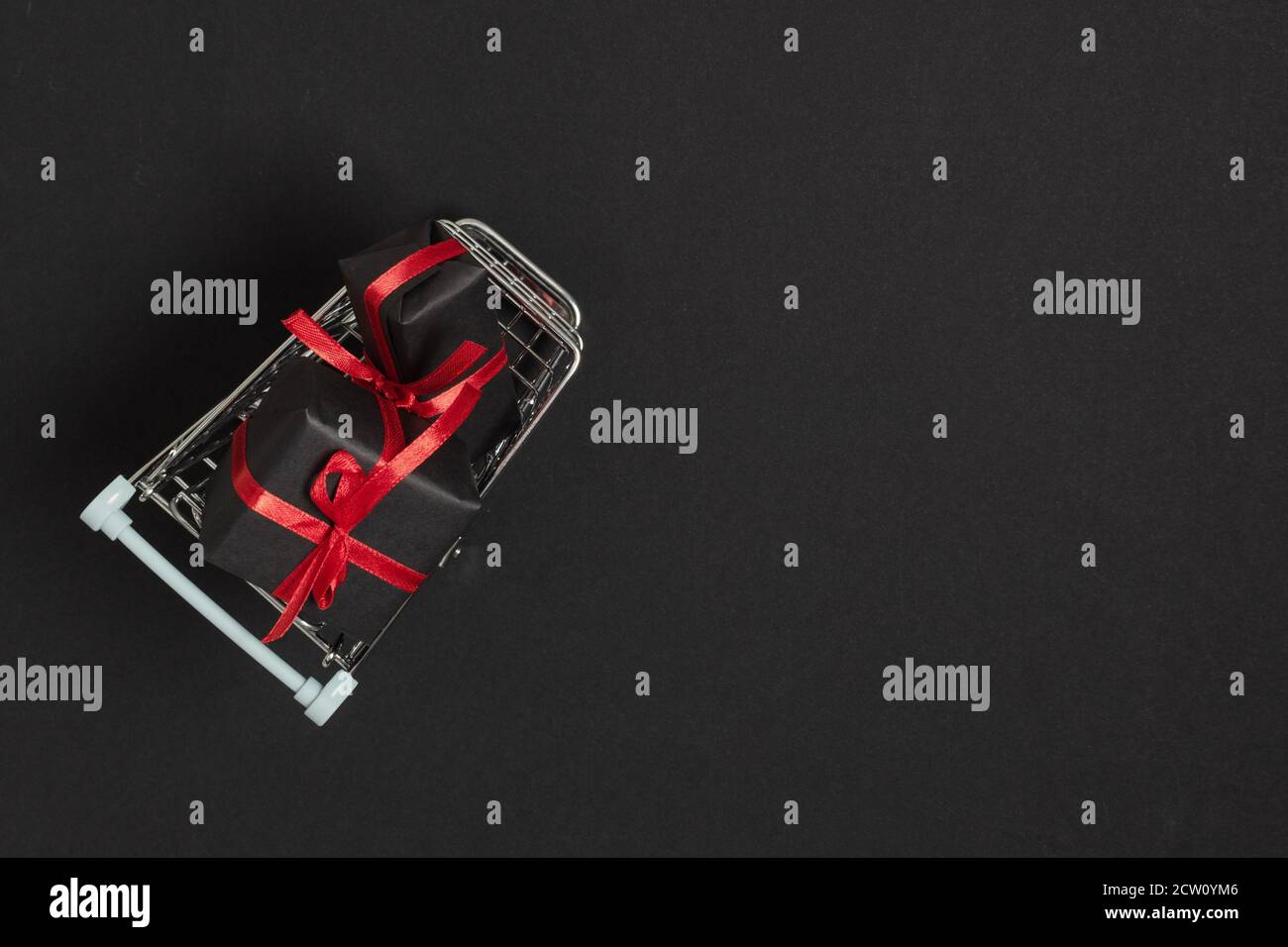 Panier avec cadeaux vue du dessus sur fond noir. Modèle du Vendredi fou pour la conception publicitaire des bannières et des circulaires. Contexte de vente dépliant ou ho Banque D'Images