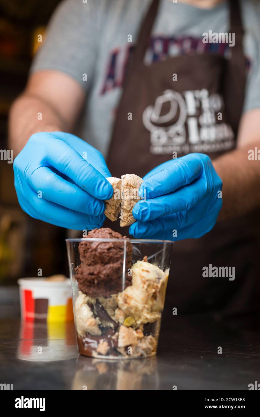 Préparation artisanale d'une tasse de verre de noix et de grains, glace italienne glace glace glace glace à la crème fouettée et biscuits à la langue du chat. Banque D'Images