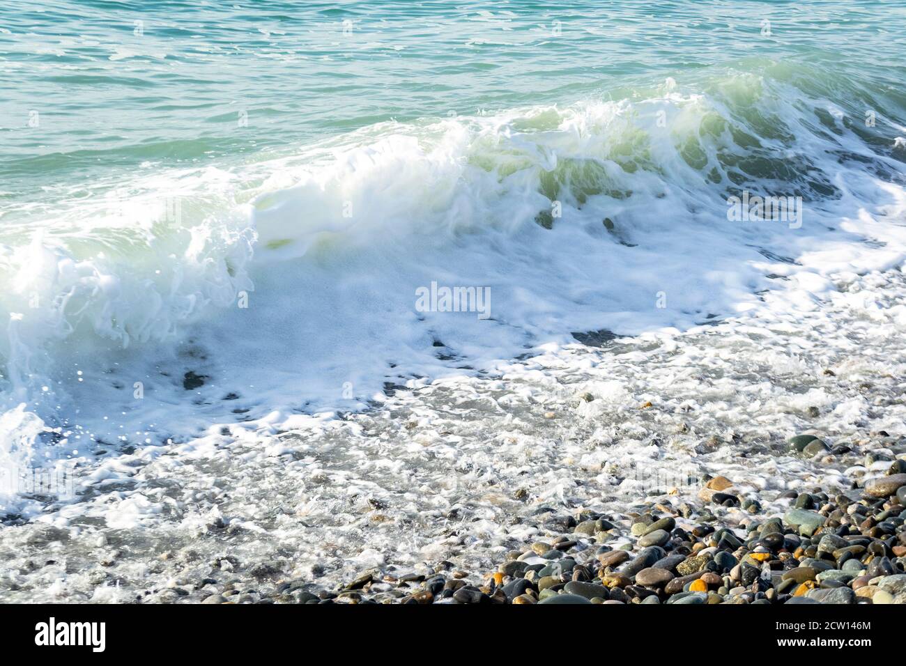 Vue magnifique sur la mer avec vagues et éclaboussures sur la plage côte en journée ensoleillée Banque D'Images