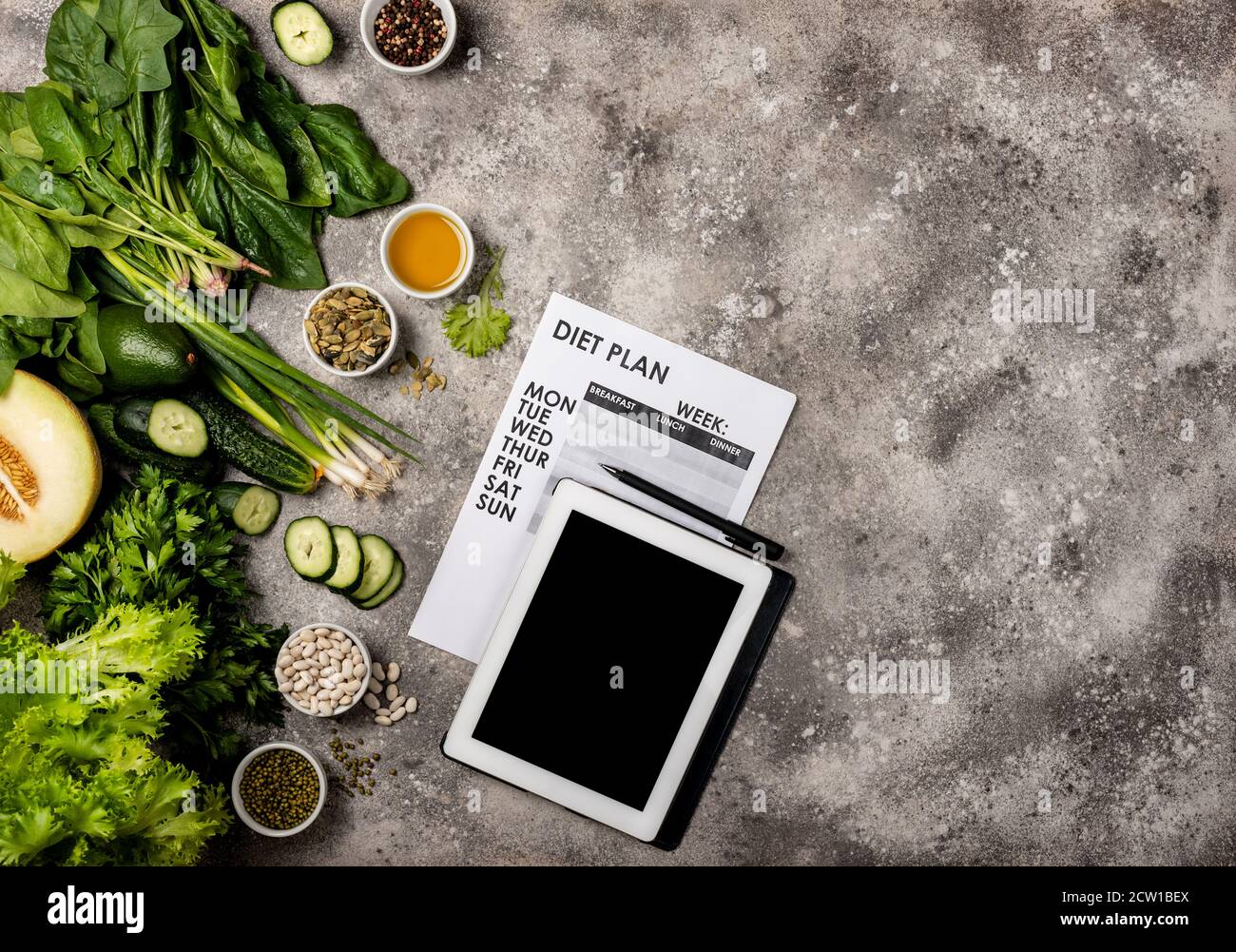 Concept de régime alimentaire. Ensemble d'aliments sains ordinateur tablette avec écran vierge et programme de perte de poids. Vue de dessus. Banque D'Images