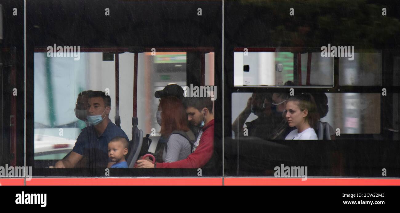 Belgrade, Serbie - 25 septembre 2020 : personnes assises et à cheval sur les sièges de fenêtre d'un bus en mouvement, de l'extérieur par temps pluvieux Banque D'Images
