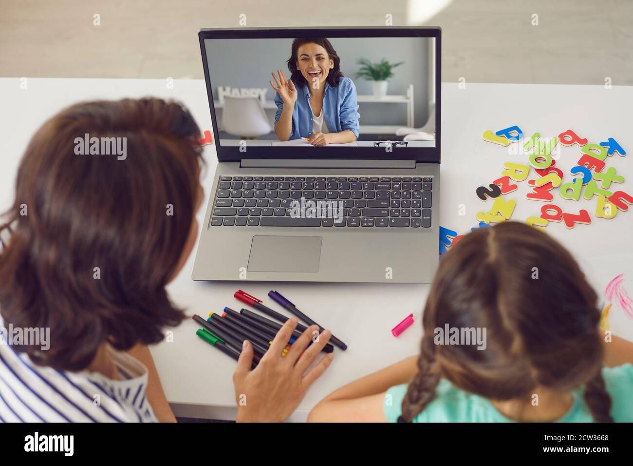 Maman et fille utilisant un ordinateur portable pour des appels vidéo avec privé Tuteur de langue anglaise Banque D'Images