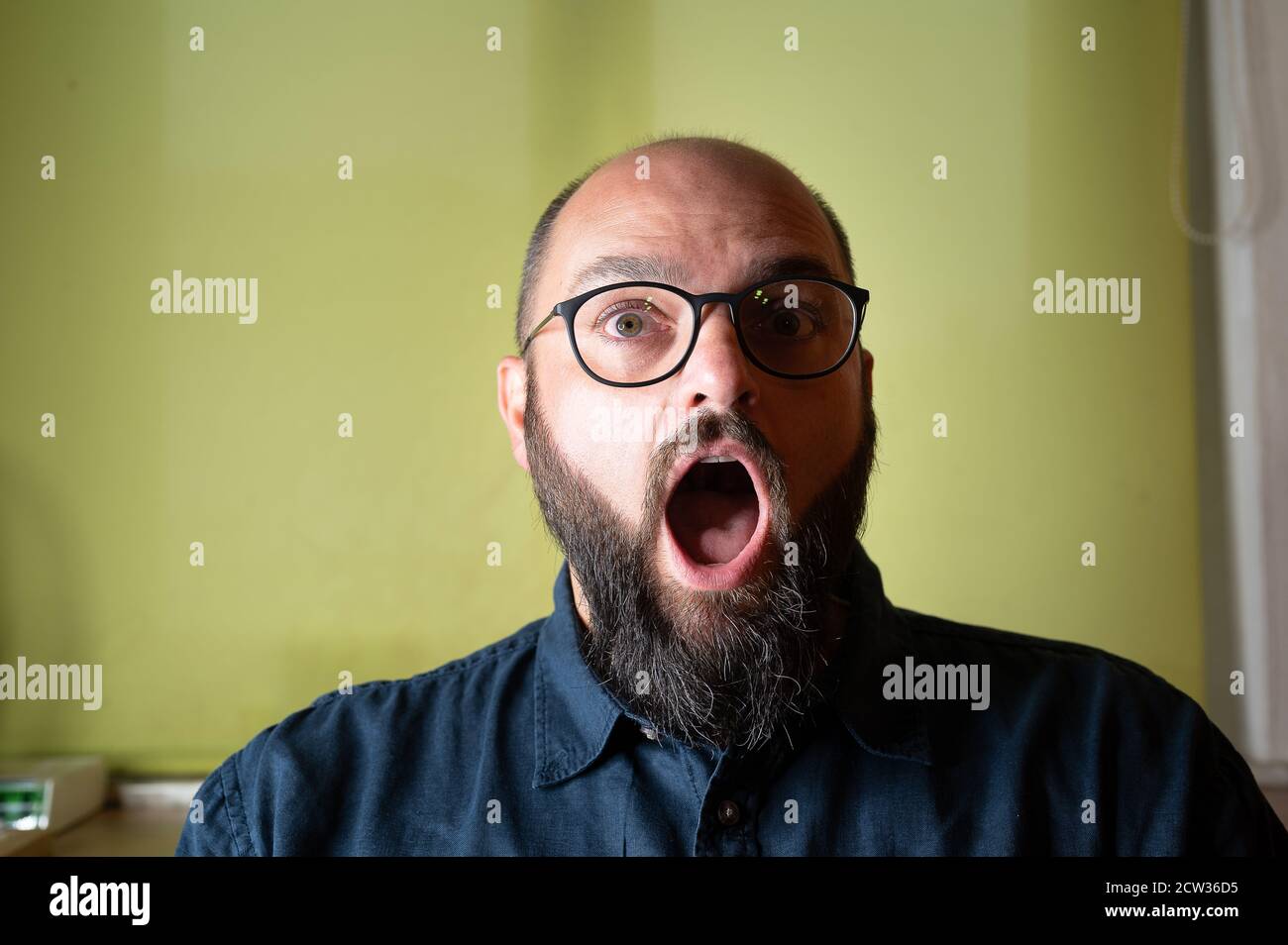 L'homme se fixe à la caméra avec sa bouche largement ouverte Banque D'Images