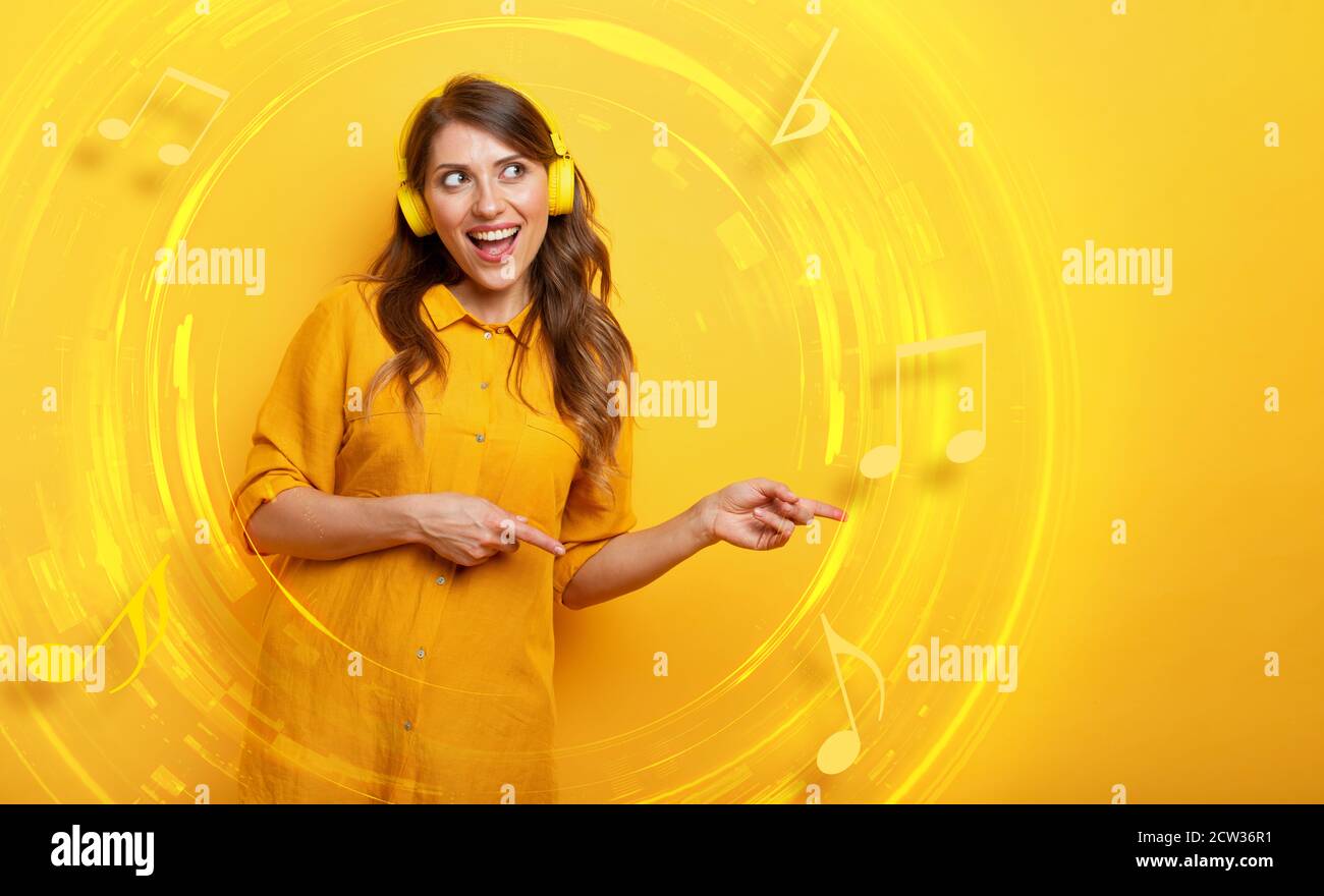 Fille avec casque jaune écoute de la musique et des danses. Expression émotionnelle et énergique. Banque D'Images