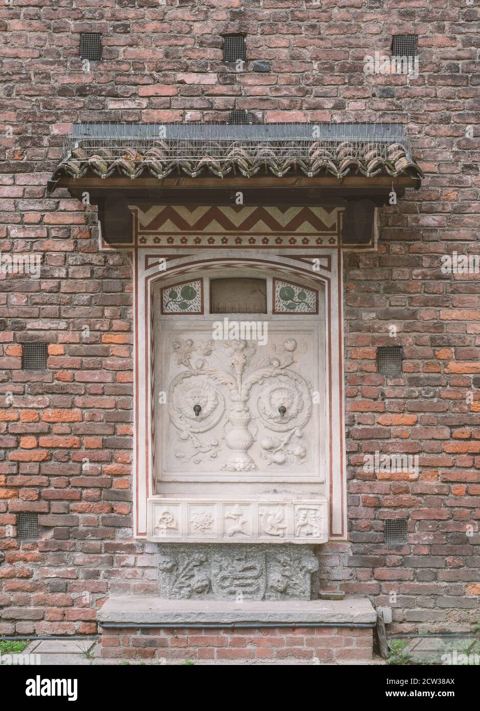 bâtiment en brique avec les restes d'une ancienne fontaine portant Les symboles de Milan.Italie médiévale Banque D'Images