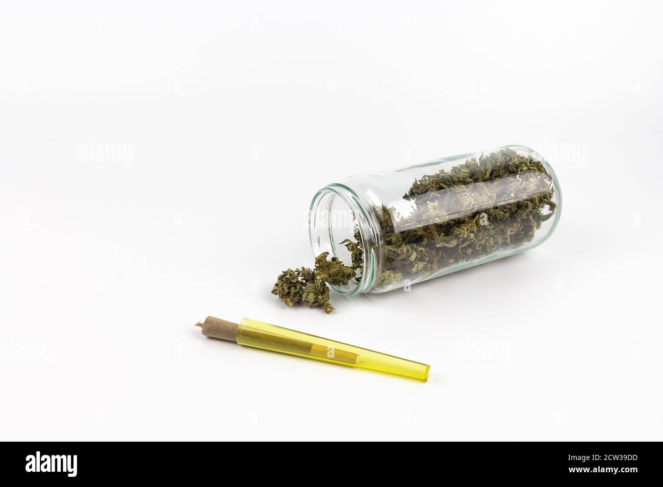 Pot en verre avec des boutons de marijuana à l'intérieur et une articulation à l'intérieur un tube en plastique jaune Banque D'Images