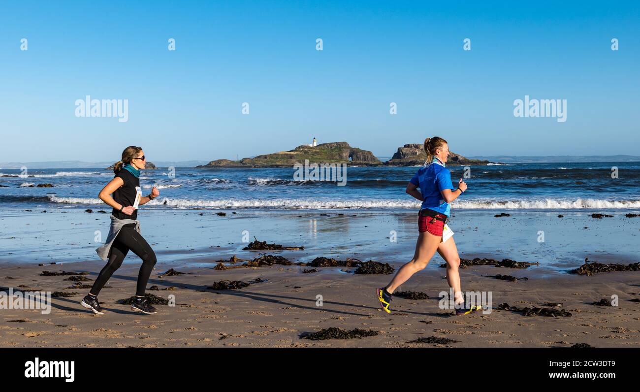 East Lothian, Écosse, Royaume-Uni, 27 septembre 2020. Scurry Running Event : les coureurs participent à un événement de course amusant de la plage de Yellowcraig à North Berwick et de retour sur une belle matinée ensoleillée d'automne. Fidra Island est à l'arrière-plan, tandis que les femmes coureuses courent sur la plage Banque D'Images