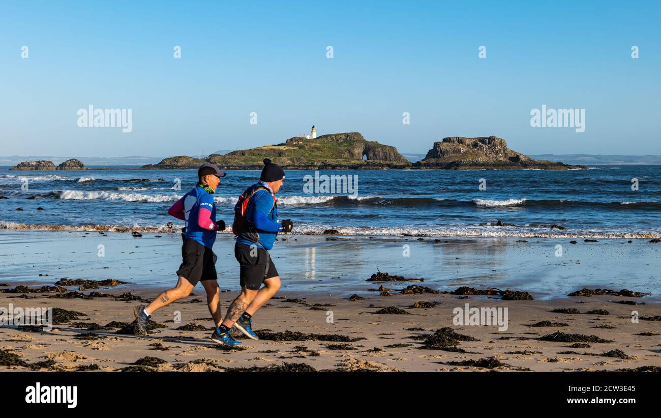 East Lothian, Écosse, Royaume-Uni, 27 septembre 2020. Scurry Running Event : les coureurs participent à un événement de course amusant de la plage de Yellowcraig à North Berwick et de retour sur une belle matinée ensoleillée d'automne. Fidra Island est à l'arrière-plan tandis que deux coureurs mâles courent sur la plage Banque D'Images
