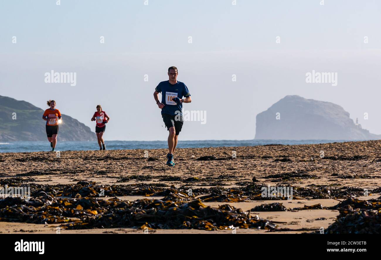 East Lothian, Écosse, Royaume-Uni, 27 septembre 2020. Scurry Running Event : les coureurs participent à un événement de course amusant de la plage de Yellowcraig à North Berwick et de retour sur une belle matinée ensoleillée d'automne. Coureur sur la plage avec Firth of Forth Islands et Bass Rock en arrière-plan Banque D'Images