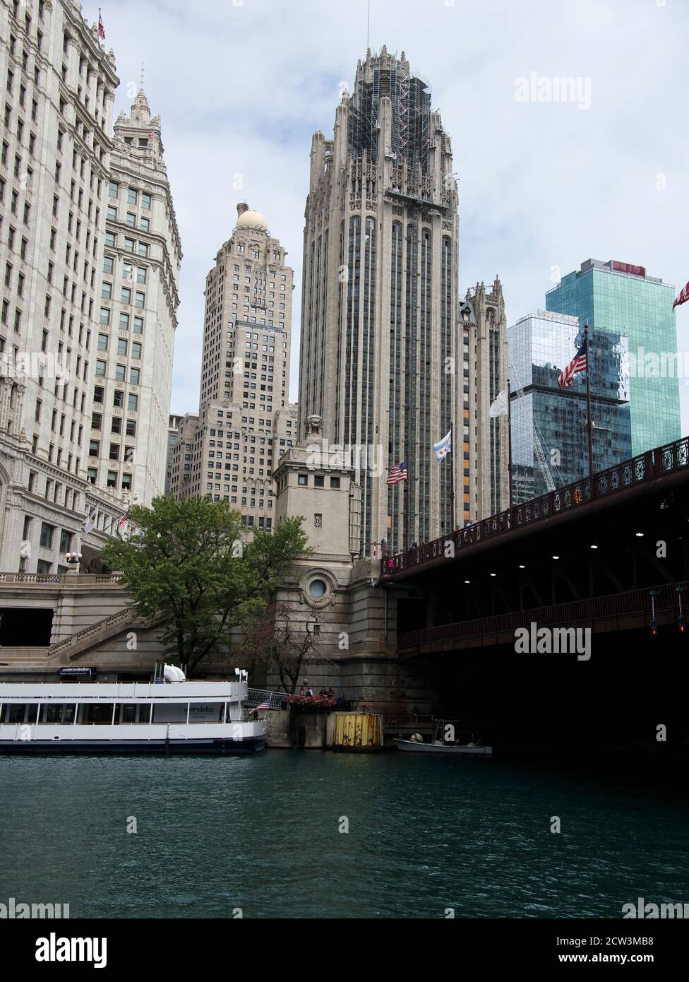 Un bateau d'excursion amarré sur la rivière Chicago à côté du pont Dusable à Chicago, Illinois, avec des bâtiments historiques derrière Banque D'Images