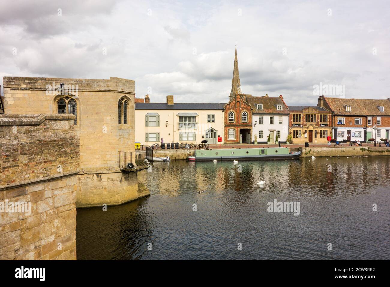 Bateau à rames et embarcation de plaisance sur le grand fleuve Ouse à St Ives Cambridgeshire Angleterre, vu du pont médiéval en pierre et de la chapelle Banque D'Images