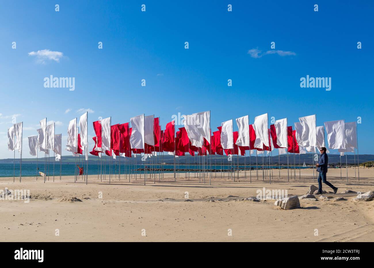 Sandbanks, Poole, Dorset Royaume-Uni. 27 septembre 2020. Les gens visitent l'œuvre de Luke Jerram « In Memoriam » sur la plage de Sandbanks, créée à partir de plus de 100 draps, une mer géante de drapeaux pour se souvenir de ceux perdus avec Covid-19, qui fait partie du festival des arts de Bournemouth by the Sea. Organisée sous la forme d'un logo médical, d'une croix rouge sur fond blanc, l'installation rend également hommage aux membres courageux du personnel du NHS et aux bénévoles qui continuent de risquer leur vie pour soigner les milliers de personnes touchées par le coronavirus. Crédit : Carolyn Jenkins/Alay Live News Banque D'Images