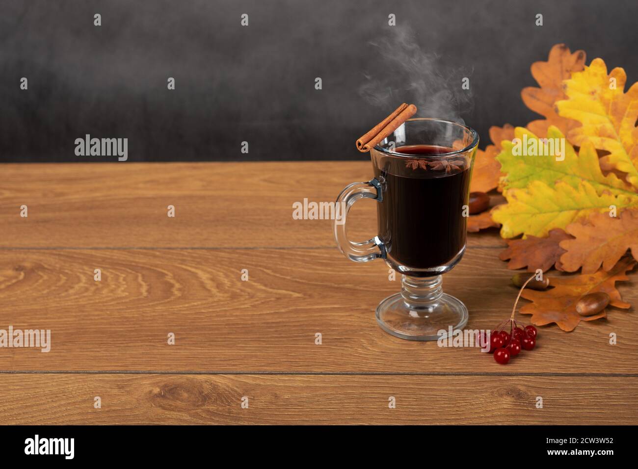 le vin chaud et les feuilles mortes d'automne. encore la vie une tasse de vin chaud avec bâton de cannelle se tient sur une table en bois sur le fond de l'oa déchue Banque D'Images