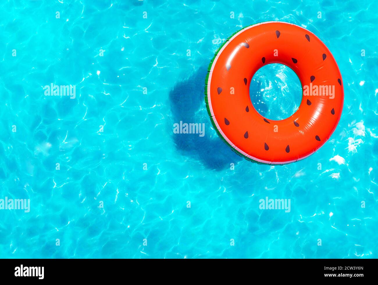 Melon d'eau gonflable rouge avec bouée de graines nager dans la natation vue sur la piscine depuis le dessus Banque D'Images