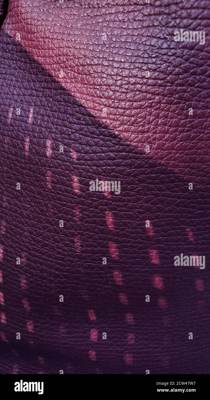 Arrière-plan violet foncé en cuir artificiel avec motif froissé et ombres pointillées. Gros plan sur les motifs géométriques Banque D'Images