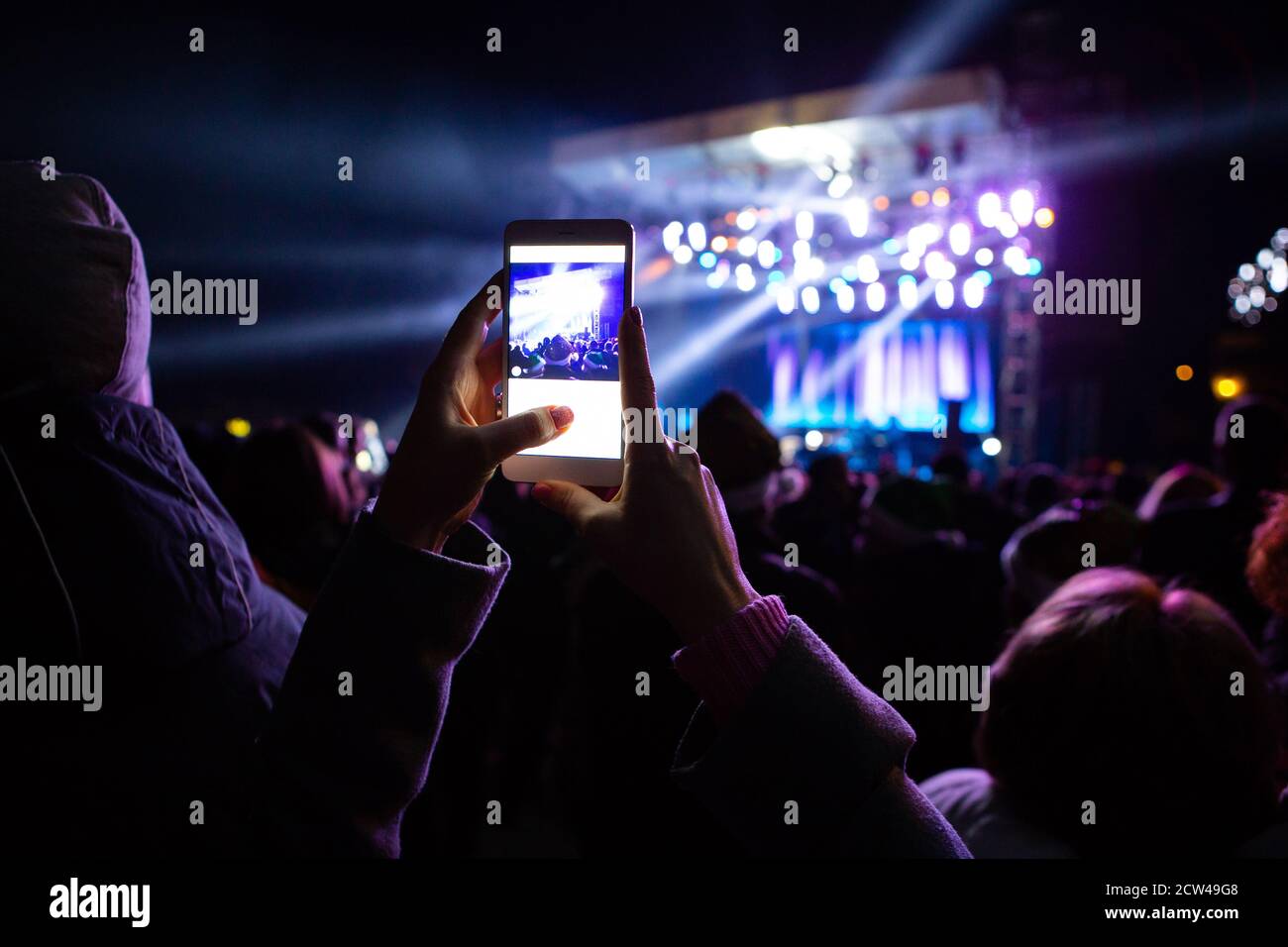 Une fille prend des photos d'un concert de rue le téléphone Banque D'Images