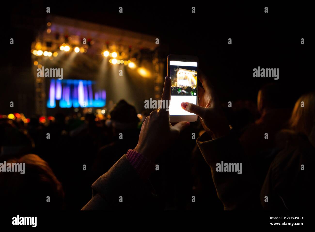 Une fille prend des photos d'un concert de rue le téléphone Banque D'Images
